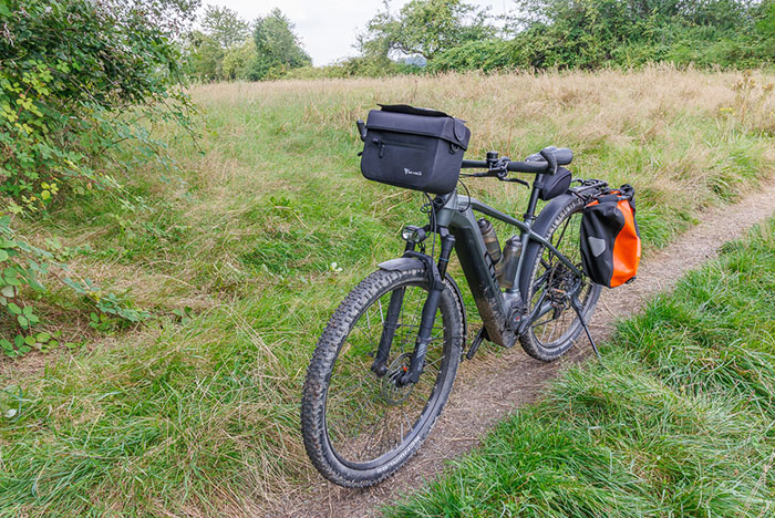 Die Lenkertasche ist von MiVelo, wasserdicht, mit abnehmbaren Handyfach. Bei einem unfreiwilligen Test auf einem groben Singetrail lösten sich die Magnete des Handyfachs mehrmals. Also nur für normale Touren geeignet, nicht für grobe Trails ;-). Meiner Meinung nach kann man auf dem Handy-Display im Fach auch nicht mehr viel erkennen, deshalb könnte man es sich auch sparen.