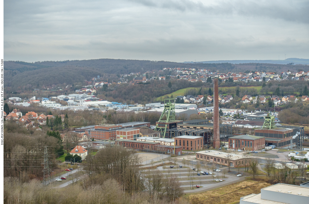 Blick von der Bergehalde Reden auf die Tagesanlage. Die Anlage wird überragt von den Fördergerüsten über den Schächten V (links) und IV (rechts)
aus den Jahren 1949 und 1939 sowie dem hohen Schornstein